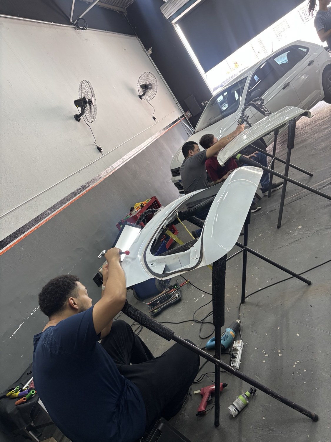 Alunos praticando em peças com ferramentas de martelinho de ouro